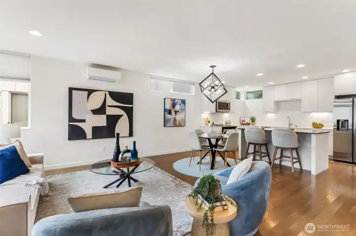 Open-concept main level with living, dining, and kitchen areas, featuring hardwood flooring and ductless mini-split system.