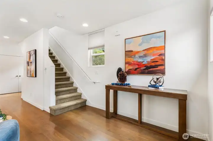 Interior stairway connecting levels with hardwood flooring and entry transition space.