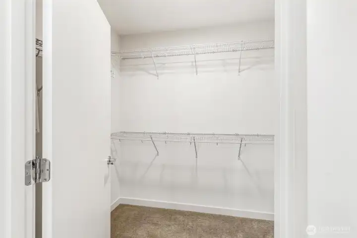 Walk-in closet with built-in shelving and hanging storage.