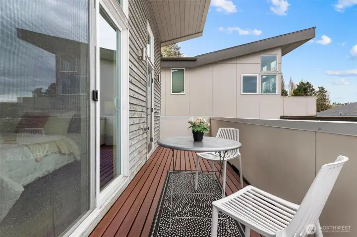Private deck off primary bedroom with composite flooring and space for seating.