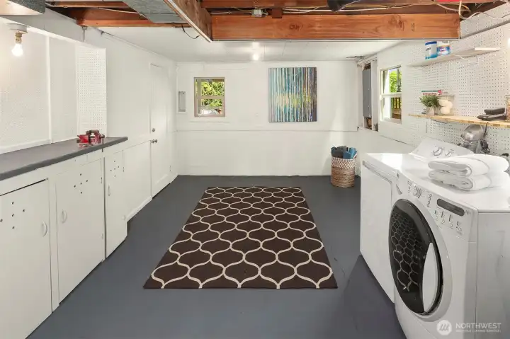 Basement area includes laundry, work bench, and storage closet under stairs.