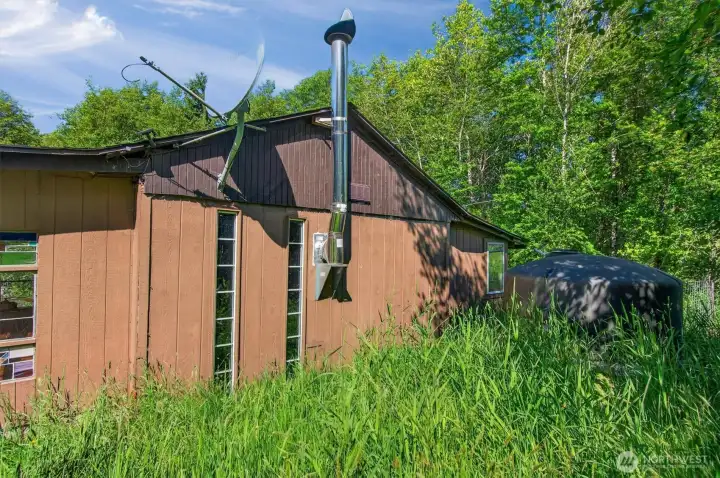 Back of cabin with water catchment tank. One of several on the property.