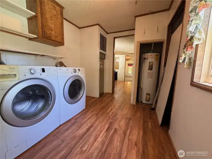 Utility room with washer, dryer, and hot water tank Utility room with washer, dryer, and hot water tank
