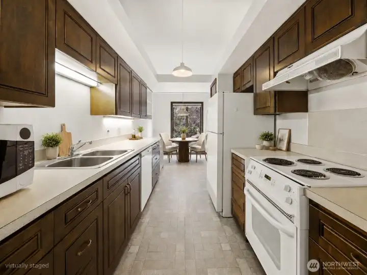 Galley kitchen with updated cabinets breakfast nook opposite of formal dinning room- virtually staged