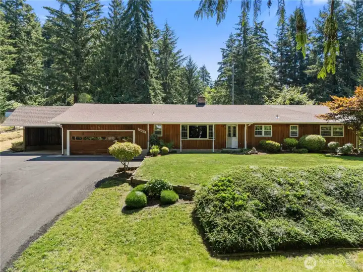 Front of the home with mature landscaping and ample parking.