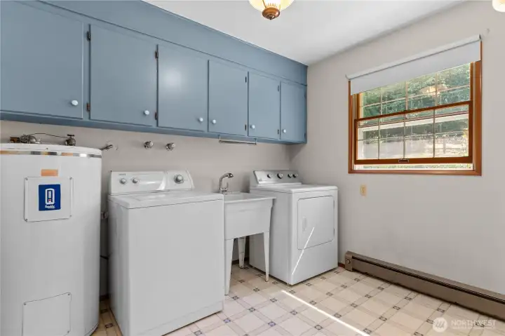 Dedicated laundry room with additional storage and workspace.