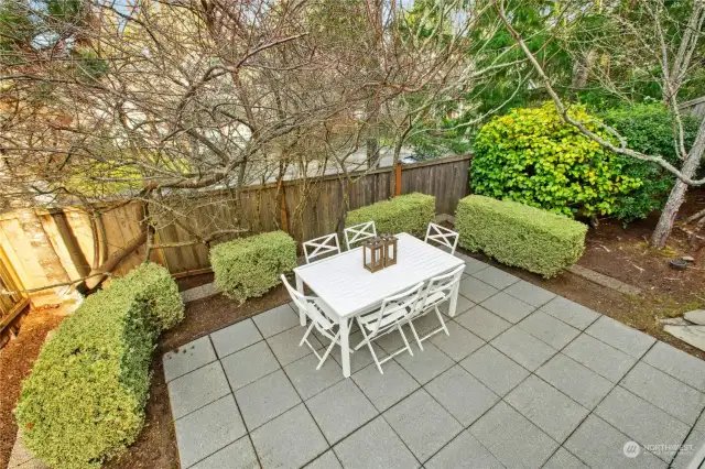 The peaceful backyard with a deck and two patio s is a great entertaining space. A tree line beyond the back fence offers privacy.