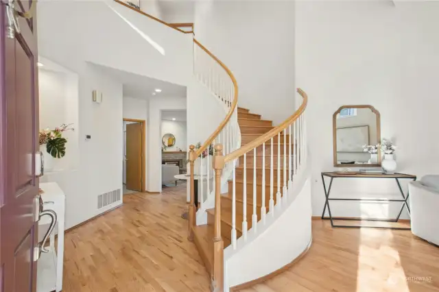 A beautiful spiral staircase and gleaming hardwood floors greet you on entry.