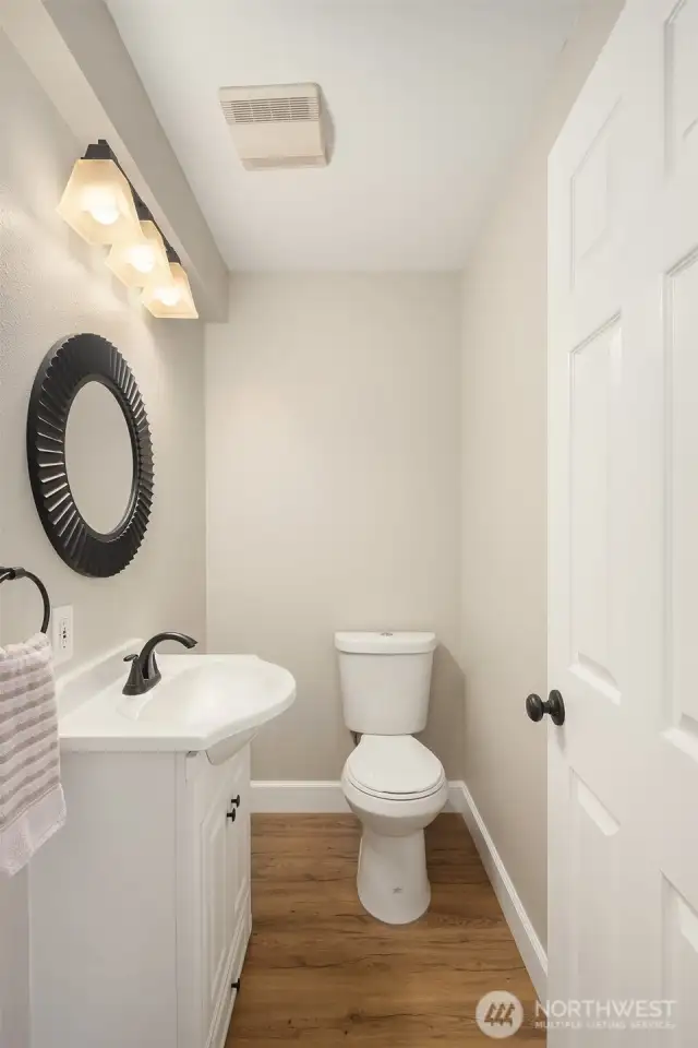 A stylish main-floor powder room is tucked just off the kitchen and dining area — perfect for guests and everyday ease.