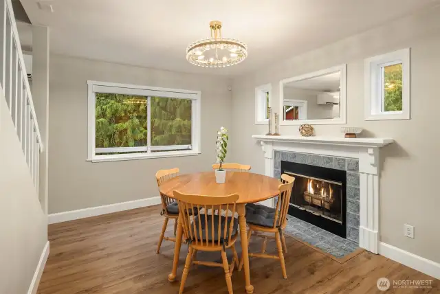 Enjoy meals by the warmth of a timeless wood-burning fireplace, accented with classic blue tile and framed by sunlit windows that bring in natural charm.
