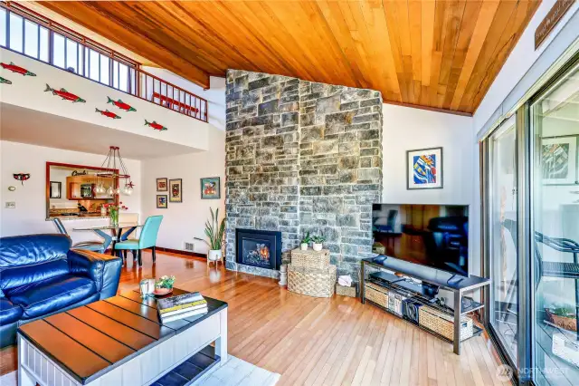 The beautiful living room with the stone fireplace wall. Note the clerestory windows above the loft on the left.