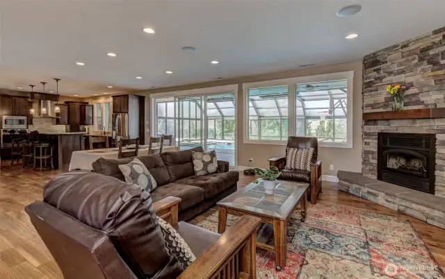 Living room with wood burning fireplace, opens up to the back patio and pool
