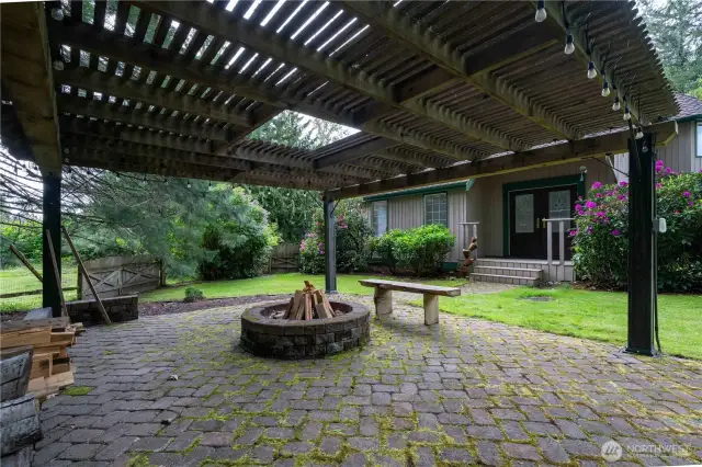 20x20 Cedar Pergola with raised fire pit and built-in seating.  Pavers lead you to the dining room.  The double doors you see are the convenient entry to the dining room.