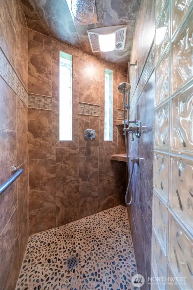 Walk-in Shower in the main floor bathroom features rain head and handheld shower.
