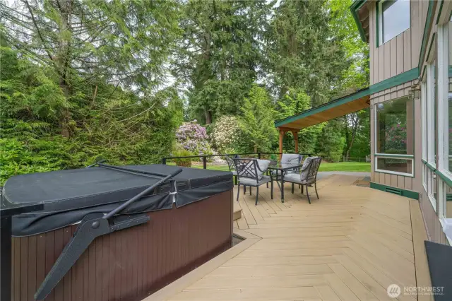 Large herringbone deck features family sized hot tub with "easy assist" lid, lots of room for seating, and covered barbecue area for year-round barbecuing.