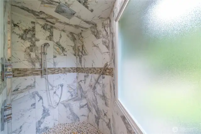 Primary shower with rain head and handheld shower heads.