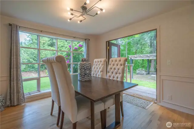 Dining room with Pella double doors that open to the cedar porch and pergola with raised fire ring.