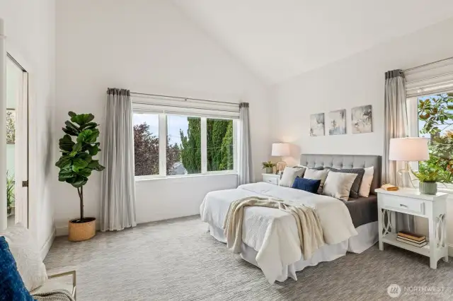 Stately primary suite with vaulted ceilings.