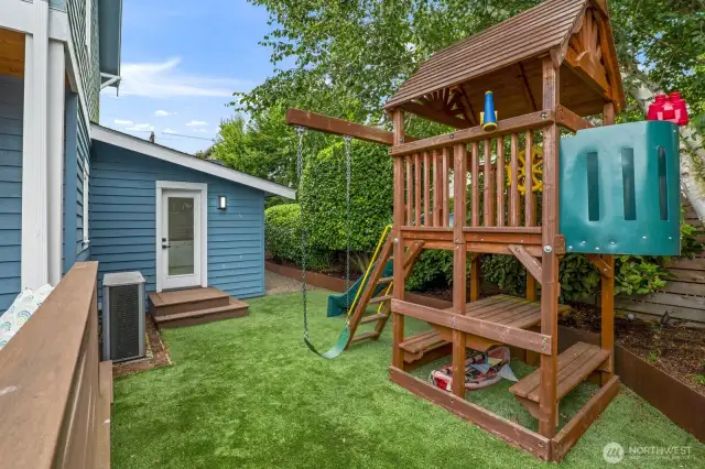 Turfed backyard with play area.