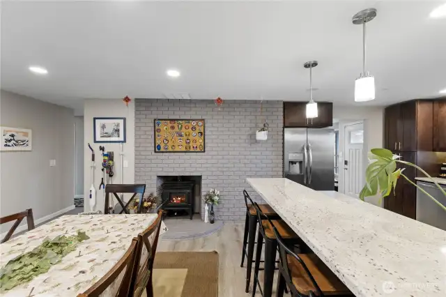 Eat-in kitchen with breakfast bar seating for stools and a cozy fireplace as the focal point.