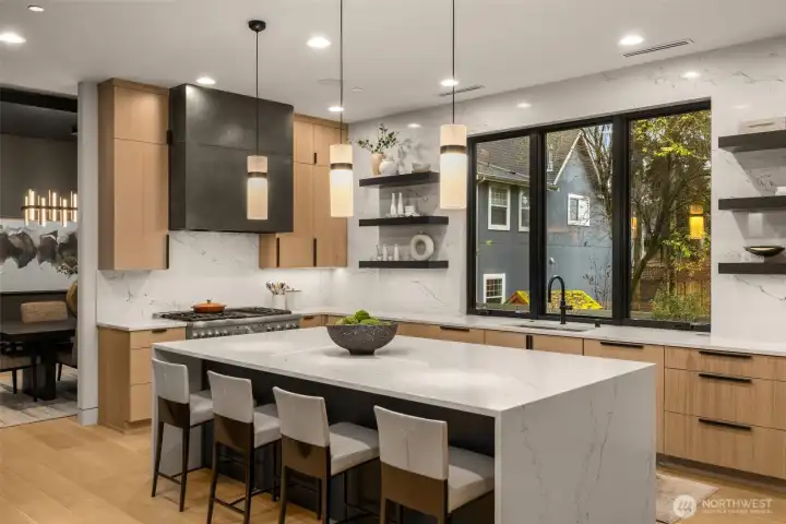 Oversized kitchen island with slab quartz and waterfall edge. Bellmont's 1900 series cabinetry.