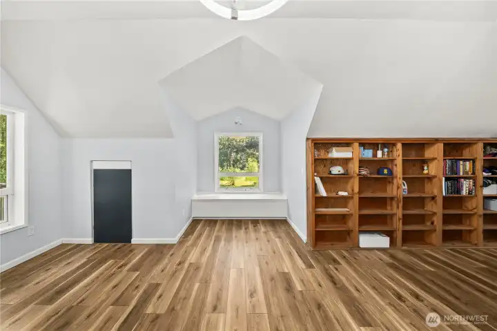 Large seating area in primary bedroom-extra storage behind bookshelf