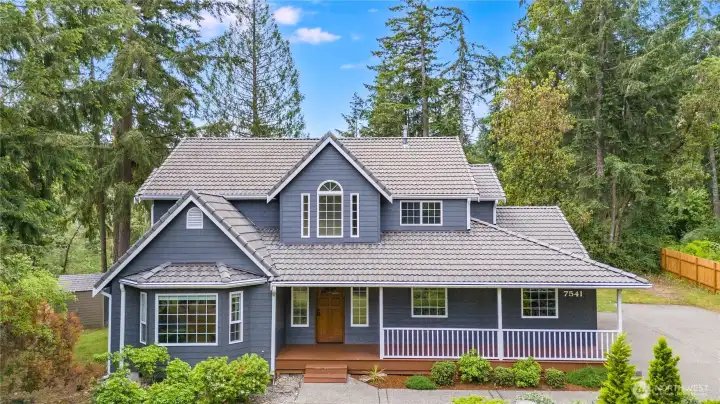 Attractive front elevation with covered front porch and mature landscaping