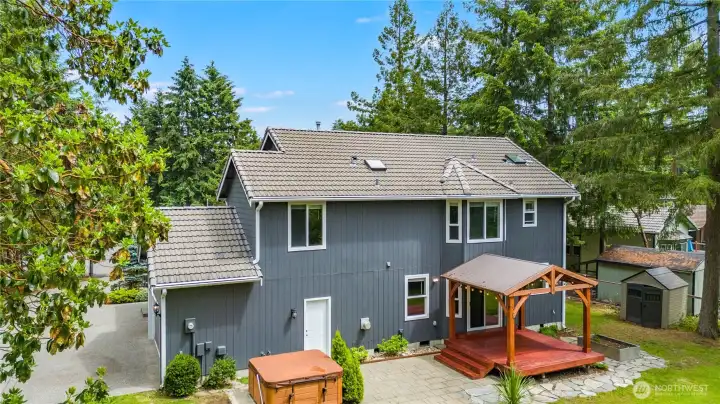 Rear view of home with spacious deck overlooking the private backyard.