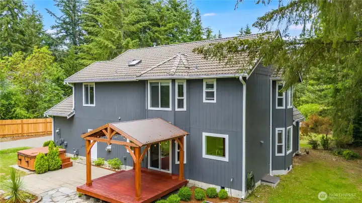 Outdoor entertaining area with covered deck and wooded surroundings