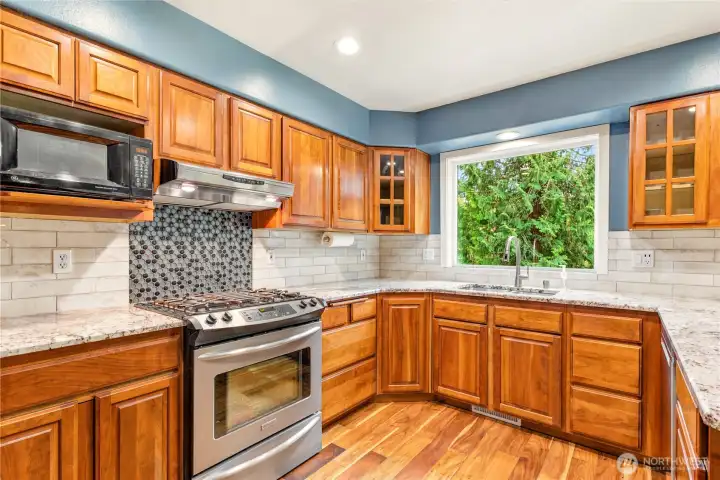 Updated kitchen with granite counters, stainless appliances, and backyard views.