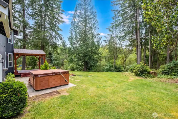Expansive lawn bordered by mature trees for added privacy