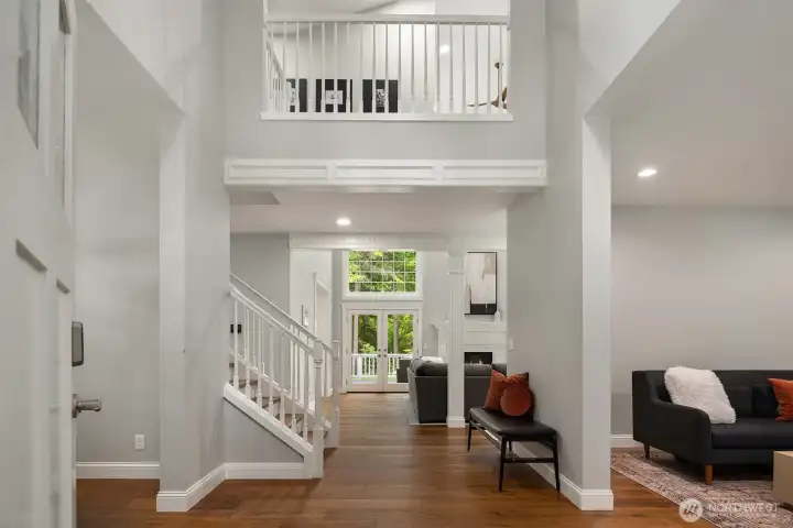 Walls of windows and soaring ceilings fill the great room with natural light, creating an inviting gathering space overlooking the private backyard.