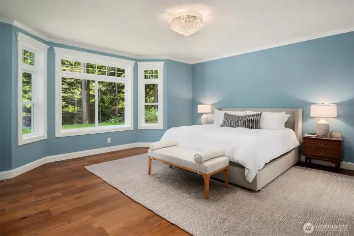 Spacious primary suite with peaceful views, abundant natural light, and a relaxing retreat overlooking mature evergreens.