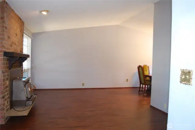 View in to the living room with hand scraped style flooring and a wood burning stove to provide peace of mind in emergencies.  This home blends functionality with location—what an opportunity!