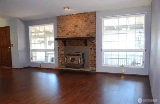 View in to the living room with hand scraped style wood flooring and a wood burning stove to provide peace of mind in emergencies.  This home blends functionality with location—what an opportunity!