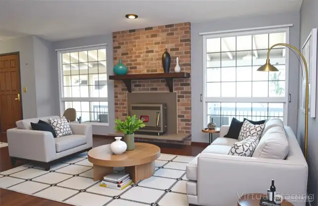 This is an virtually staged view in to the living room with hand scraped style wood flooring and a wood burning stove to provide peace of mind in emergencies.  This home blends functionality with location—what an opportunity!