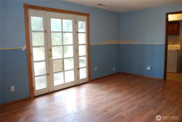 View across the family room showing patio door and into the laundry room.  Patio off family room is great for outdoor entertaining, BBQs, or simply relaxing. Plenty of backyard space for an RV and backyard fun, includes shed.