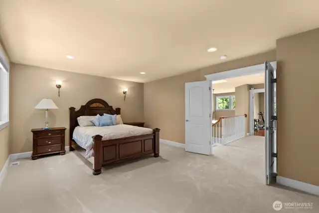 Primary Suite with double doors and space for sitting area walk in closet and a closet for him