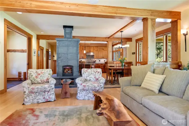 Open living and dining areas centered around a Tulikivi soapstone fireplace with built-in pizza oven—perfect for cozy evenings and entertaining.