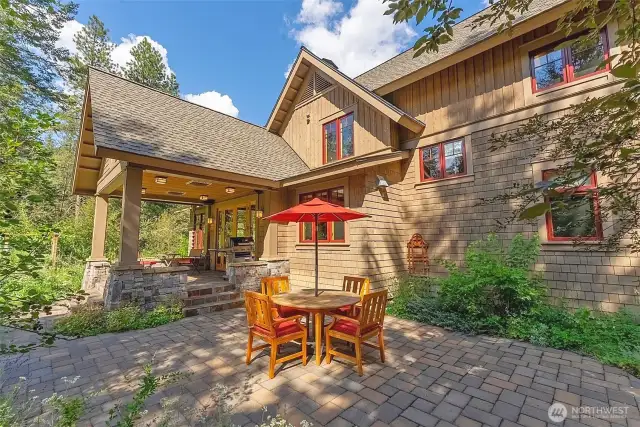 Stone patio and pavers nestled beside native plantings and gardens.