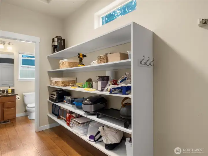 Just in from the garage is this large pantry area. Super convenient storage. The powder room is at the end of the hall.