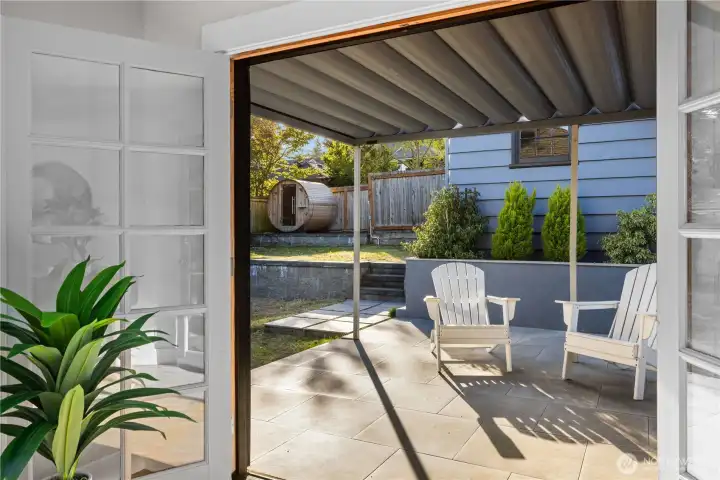 New patio and terraced backyard with sauna and detached garage accessed through alley with additional parking space