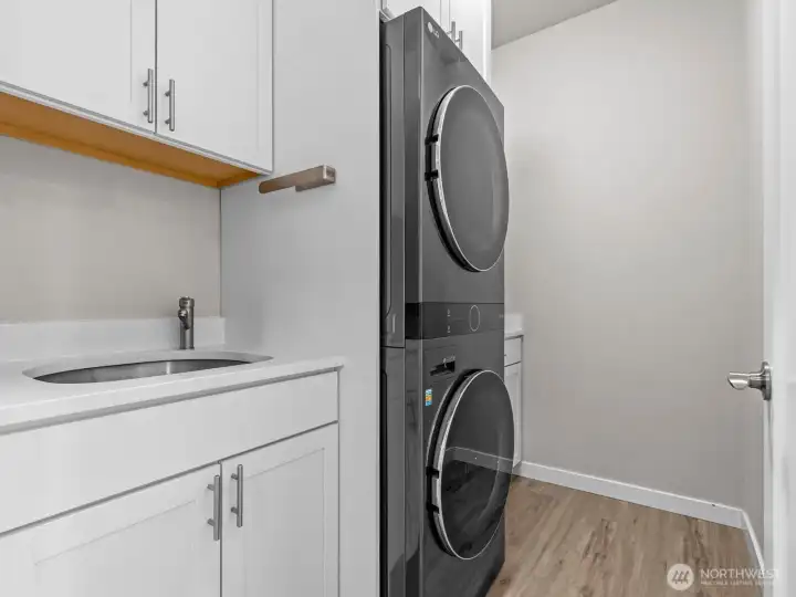 Across the hall is the upgraded laundry room with built in laundry center, utility sink and an abundance of additional storage space.