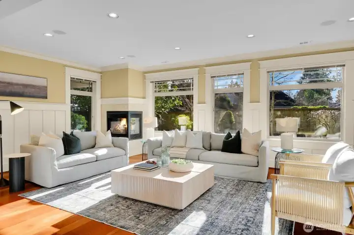 Sun drenched formal living room overlooks the fenced in back yard
