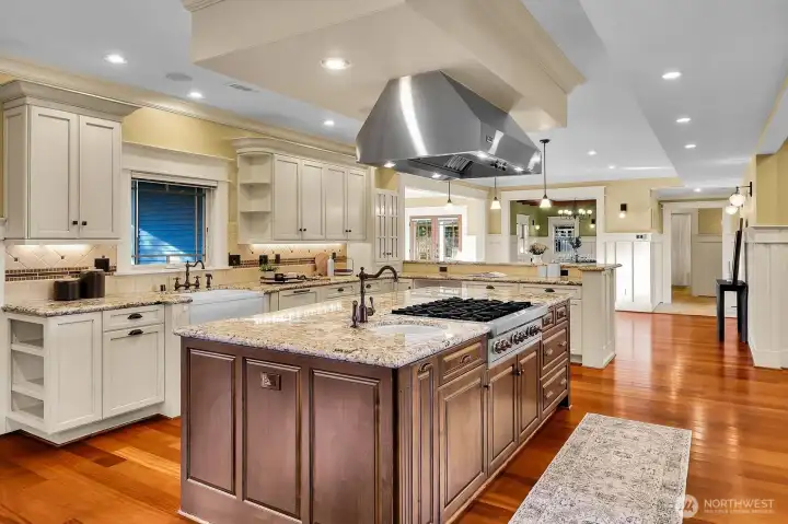 A Wolf 6-burner gas range and prep sink are found on the kitchen island