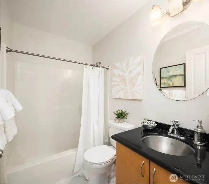 ull bathroom with tub/shower combination, solid surface vanity, and modern fixtures.