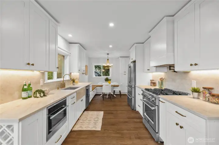 Ceiling-height shaker cabinetry with custom trim details and brushed brass hardware. Built in hood & pot filler