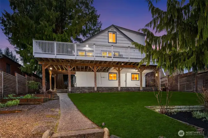 Additional entrance off the patio under the deck to the lower level. Plenty of yard to play in and gardening boxes to the left. Note same fenced fully around the lot.