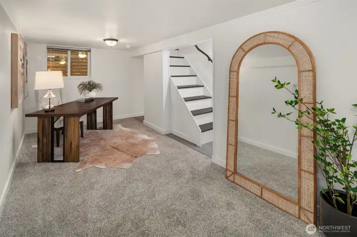 Stairs to Lower Level rec room area staged as an office space.