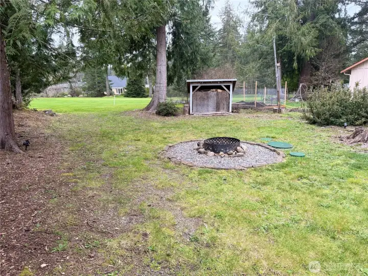 Flat land. Firepit looks to golf course. Shed is on the right.